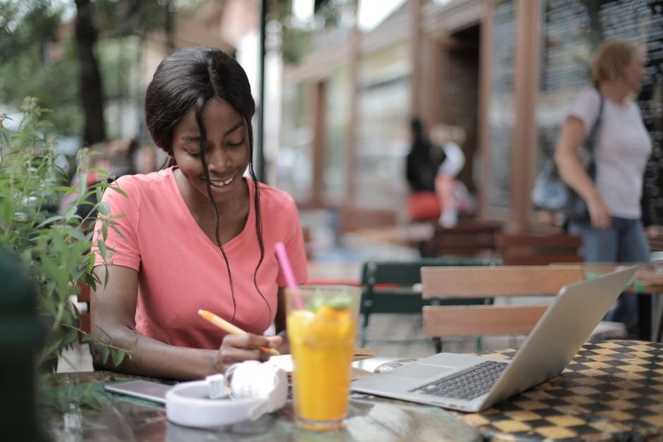 Personne rédigeant du contenu sur un ordinateur portable en terrasse